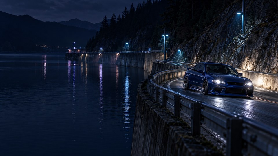 A midnight-blue unbranded tuner sedan rounds a reservoir switchback at night, with white headlights, cyan roadside lamps, dark mountain rock and violet reflections on the water.
